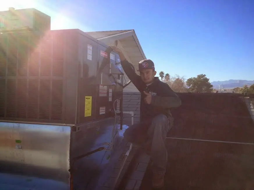 HVAC technician performing Air Duct Repair on a rooftop unit in Gibsonville